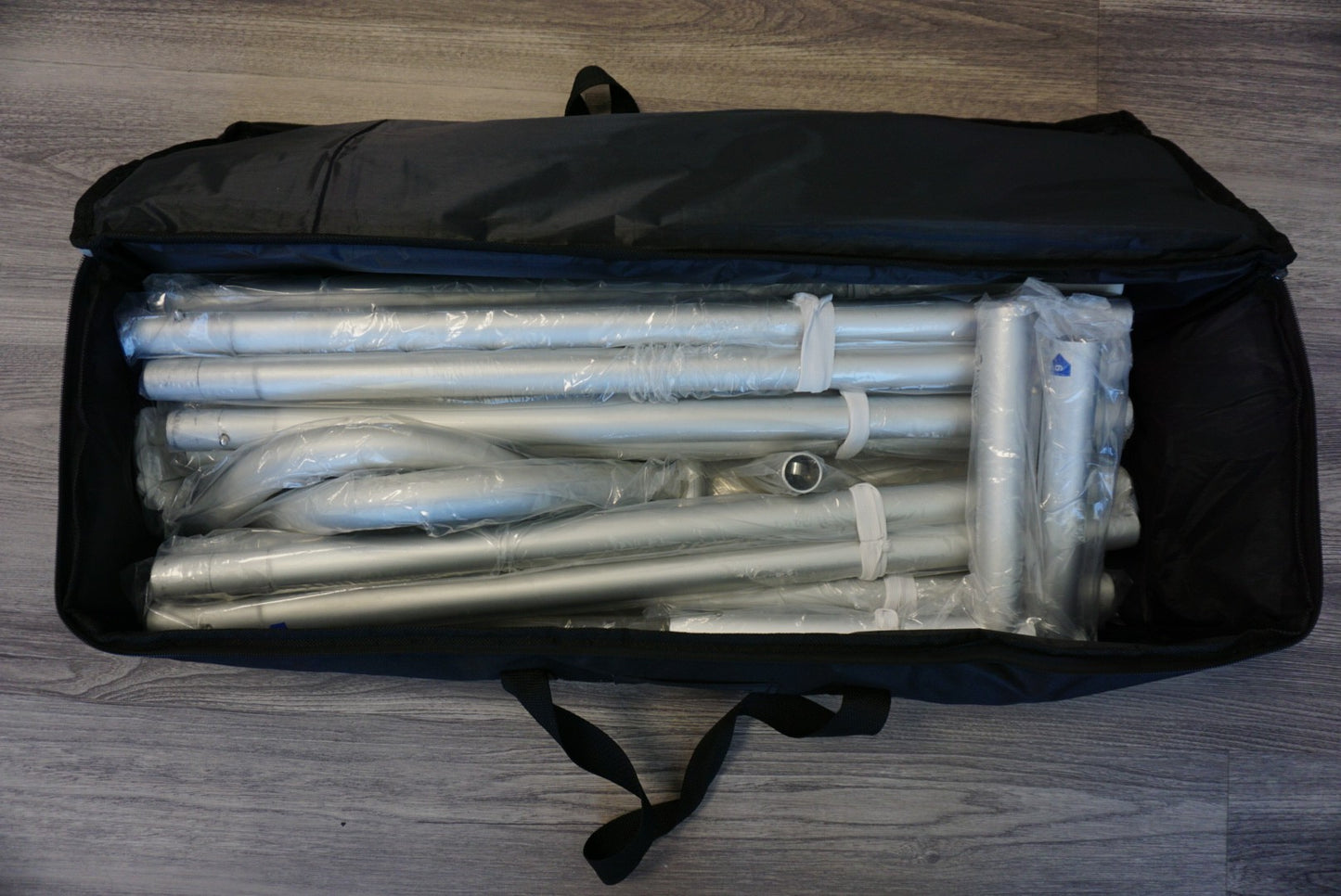 Heavy-duty canvas carry bag for tension fabric backdrop stands with reinforced handles for easy transport.