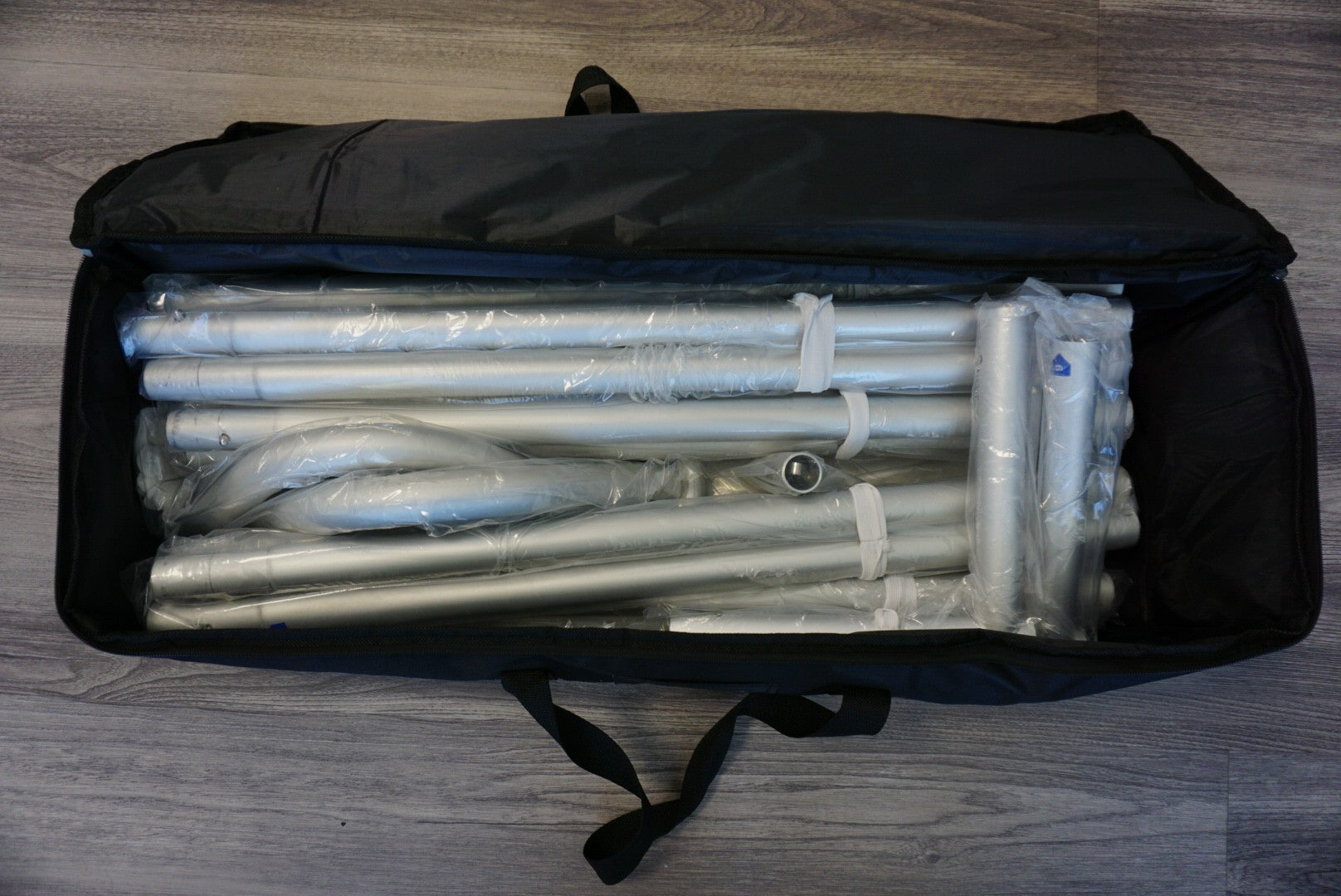 Heavy-duty canvas carry bag for tension fabric backdrop stands with reinforced handles for easy transport.